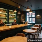 Home 16 네덜란드에서 대마초 구매 가능 장소 - A cozy and modern Dutch coffeeshop interior with warm lighting, wooden furniture, and shelves displa...